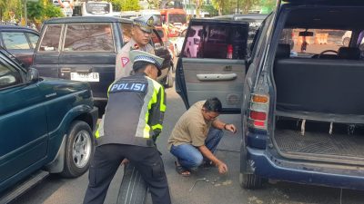 Gercep personil Lantas Polres Bondowoso Membantu Mobil Rombongan yang akan Menghadiri Acara Manasik Haji yang Mengalami Pecah Ban